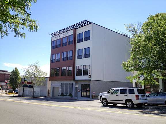 A white building with a red and brown sign on it.